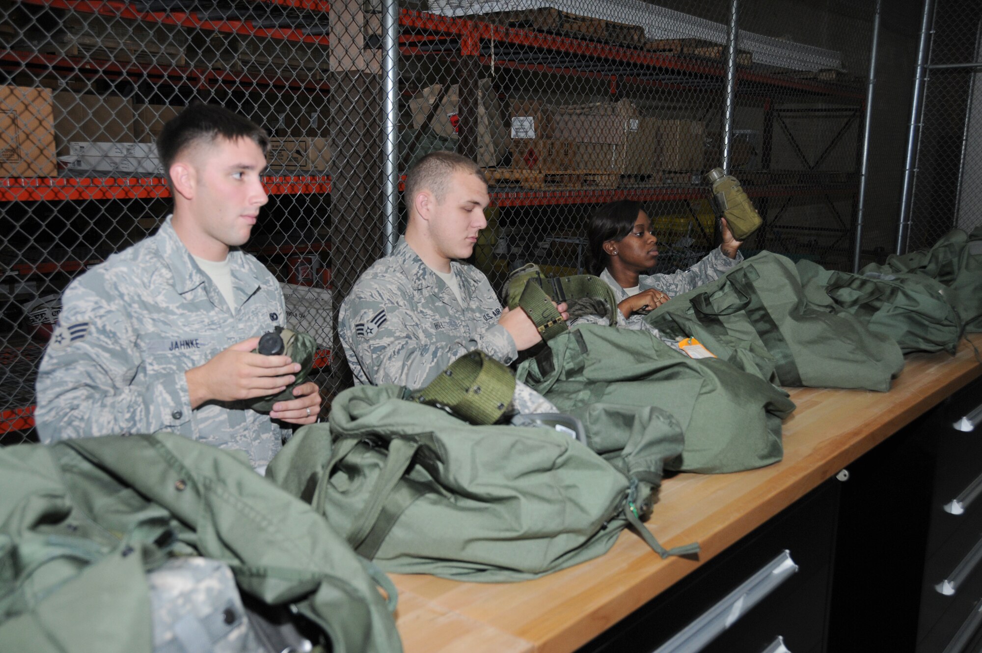 From left, Senior Airmen Joseph Jahnke and Christopher Hill and Airman 1st Class Porsha Hazzard inspect their deployment mobility bags at the supply warehouse during a deployment exercise Aug. 26.  Airman Jahnke and Hazzard are from the 81st Security Forces Squadron.  Airman Hill is assigned to the 81st Force Support Squadron. (U.S. Air Force photo by Kemberly Groue)