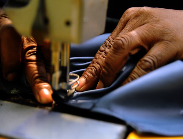 Isreal Middleton stitches together a cover for a C-17 Globemaster III pilot chair headrest Sept. 1, 2010, on Joint Base Charleston, S.C. The fabric shop makes many diverse products for the base as well as repairs and maintains equipment which can save a great deal of money on replacements. The shop makes everything from headrest covers to pilot seat covers out of sheep skin while repairing equipment like floatation rafts and cargo nets used by the 437th Aerial Port Squadron. Mr. Middleton is a fabric worker with the 437th Operations Support Squadron. (U.S. Air Force photo/Senior Airman Timothy Taylor)