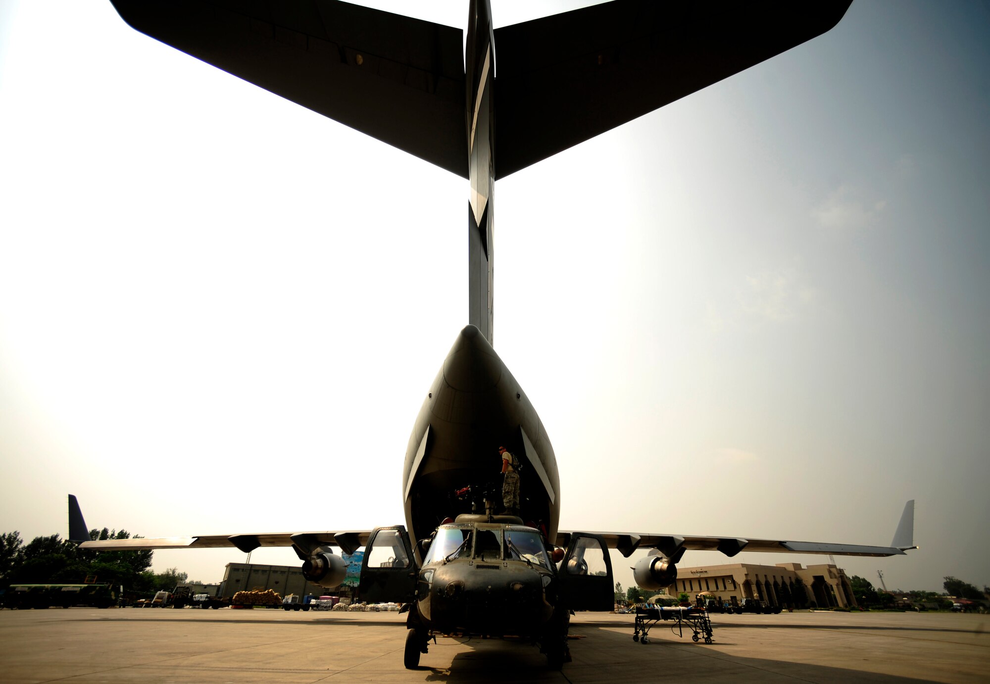 U.S. Air Force airmen from the 818th Contingency Response Element and U.S. Army soldiers from the 16th Combat Aviation Brigade take the straps off of UH-60 Blackhawk helicopters and cargo aboard a C-17 Globemaster III aircraft at Chaklala Air Force Base, Pakistan on Sept. 1, 2010. The 16th CAB just arrived in Pakistan and is going to air transport supplies throughout the country.

(U.S. Air Force photo by Staff Sgt. Andy M. Kin / Released)