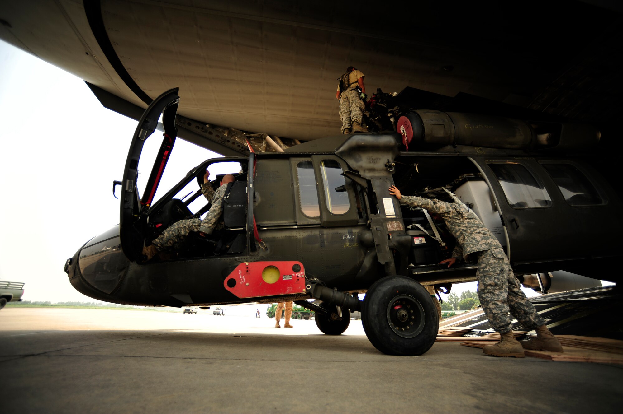 U.S. Air Force airmen from the 818th Contingency Response Element and U.S. Army soldiers from the 16th Combat Aviation Brigade, take the straps off of UH-60 Blackhawk helicopters and cargo aboard a C-17 Globemaster III aircraft at Chaklala Air Force Base, Pakistan on Sept. 1, 2010. The 16th CAB just arrived in Pakistan and are going to air transport supplies throughout the country.
(U.S. Air Force photo by Staff Sgt. Andy M. Kin / Released)