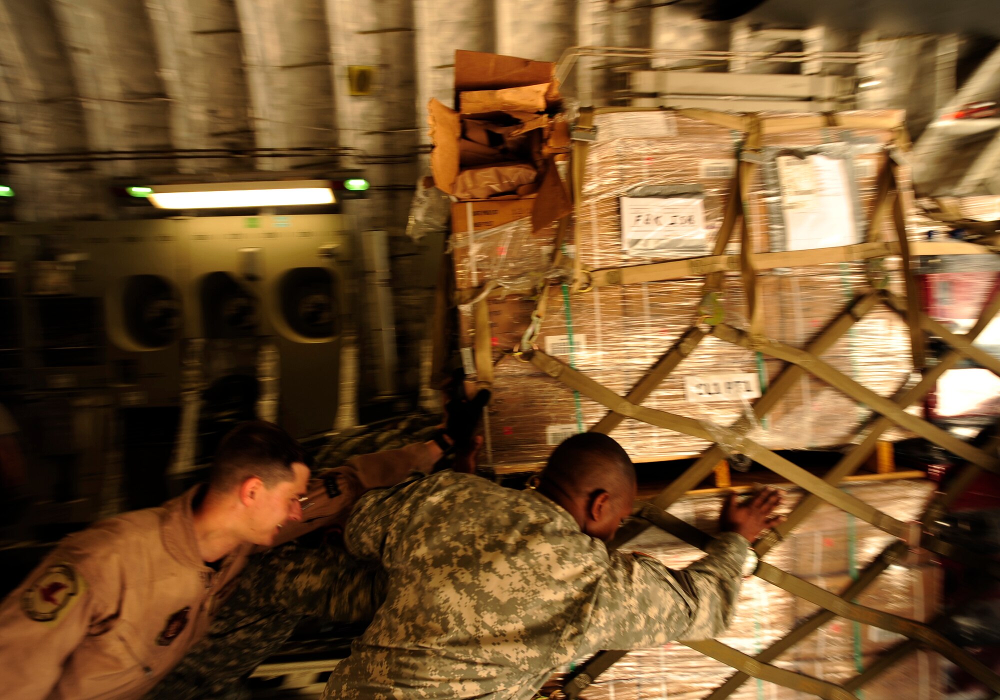 U.S. Air Force airmen from the 818th Contingency Response Element and U.S. Army soldiers from the 16th Combat Aviation Brigade take the straps off of UH-60 Blackhawk helicopters and cargo aboard a C-17 Globemaster III aircraft at Chaklala Air Force Base, Pakistan on Sept. 1, 2010. The 16th CAB just arrived in Pakistan and is going to air transport supplies throughout the country.

(U.S. Air Force photo by Staff Sgt. Andy M. Kin / Released)