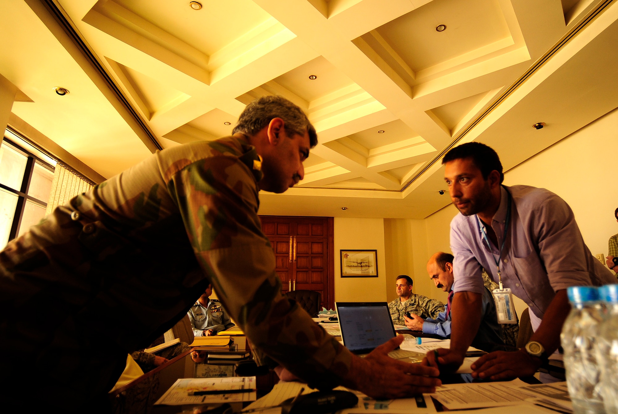 Pakistan Army Col. Khalil Dar (left) and  John from the World Food Program talk rotary wing support in designated locations in support of flood relief efforts during an initial Air Coordination Cell meeting at Chaklala Air Field, Pakistan on Aug. 28, 2010.  The ACC was formed to discuss available food and supply requirements needed in flooded areas throughout Pakistan and means for transporting items all over country.(U.S. photo taken by Staff Sgt. Andy M. Kin)