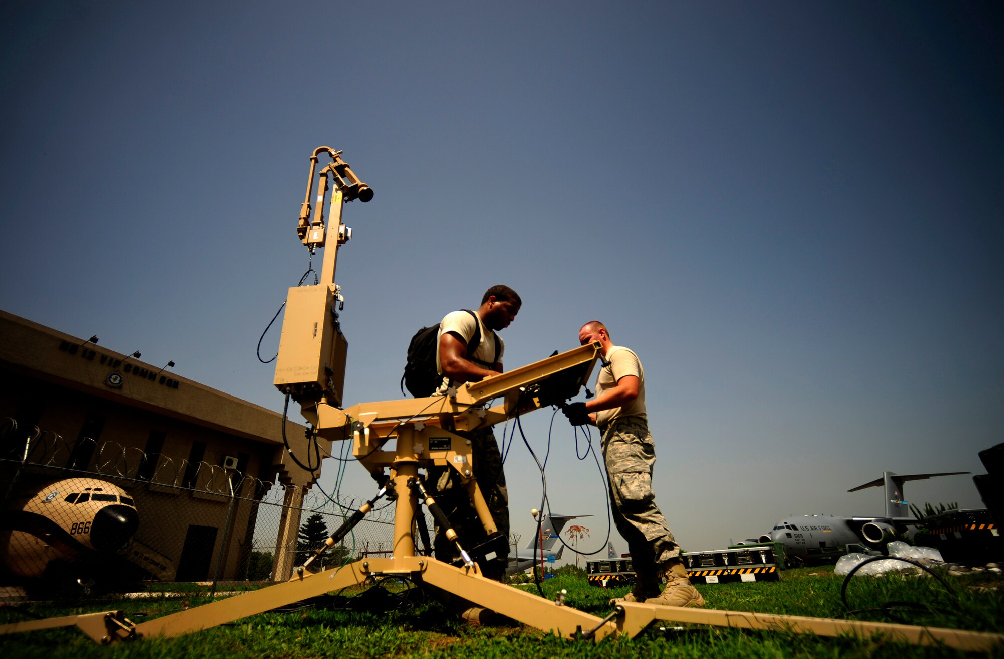 A U.S. Air Force airmen from the Contingency Response Team, 88th CRG McGuire Air Force Base, NJ set up antennas for internet and telephone capabilities during initial CRT build up at Chaklala Air Field, Pakistan on Aug. 28, 2010. The CRT arrived today taking over responsibilities for loading and off loading U.S. aircraft with supplies all over Pakistan in support of flood relief efforts.

(U.S. photo taken by Staff Sgt. Andy M. Kin)