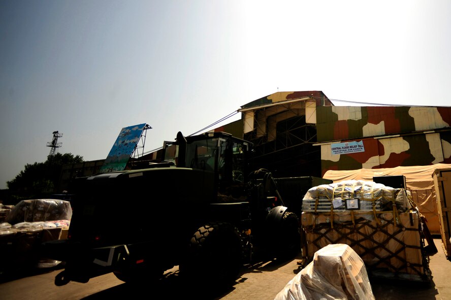 A Pakistani worker operates a forklift moving pallets of food out of the Pakistan Air Force's Central Flood Relief Cell to a designated spot for air transport at Chaklala Air Force Base, Pakistan, in support of flood relief efforts on Aug. 28, 2010. The U.S. Air Force's 621st Contingency Response Element from Joint Base McGuire-Dix-Lakehurst, N.J., arrived to augment local loading and off loading operations and to carry out loading and offloading of U.S. aircraft. (U.S. Air Force Photo/Staff Sgt. Andy Kin)
