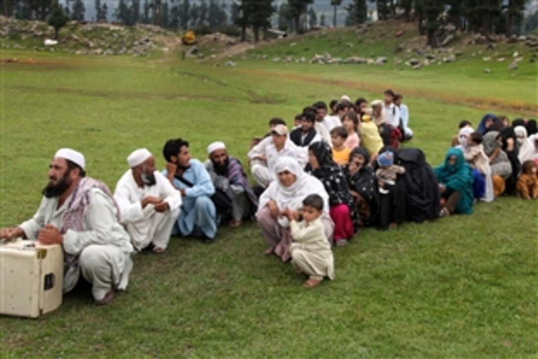 Pakistani flood victims wait to be evacuated by U.S. Navy pilots as part of the flood relief relocation process in Swat Valley, Pakistan, Sept. 5, 2010. The pilots are assigned to the 15th Marine Expeditionary Unit.