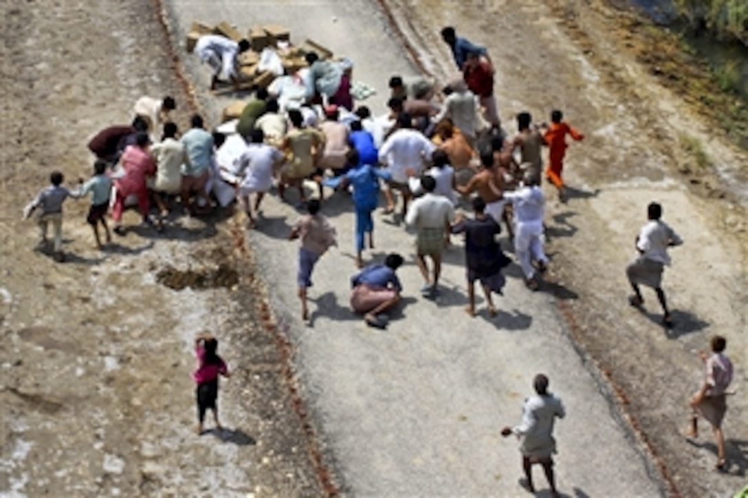 Pakistani flood victims rush to pick up relief supplies delivered by U.S. Marines during humanitarian relief efforts in the southern region of Pakistan, Sept. 4, 2010. The Marines are assigned to Marine Medium Helicopter Squadron 165, 15th Marine Expeditionary Unit.