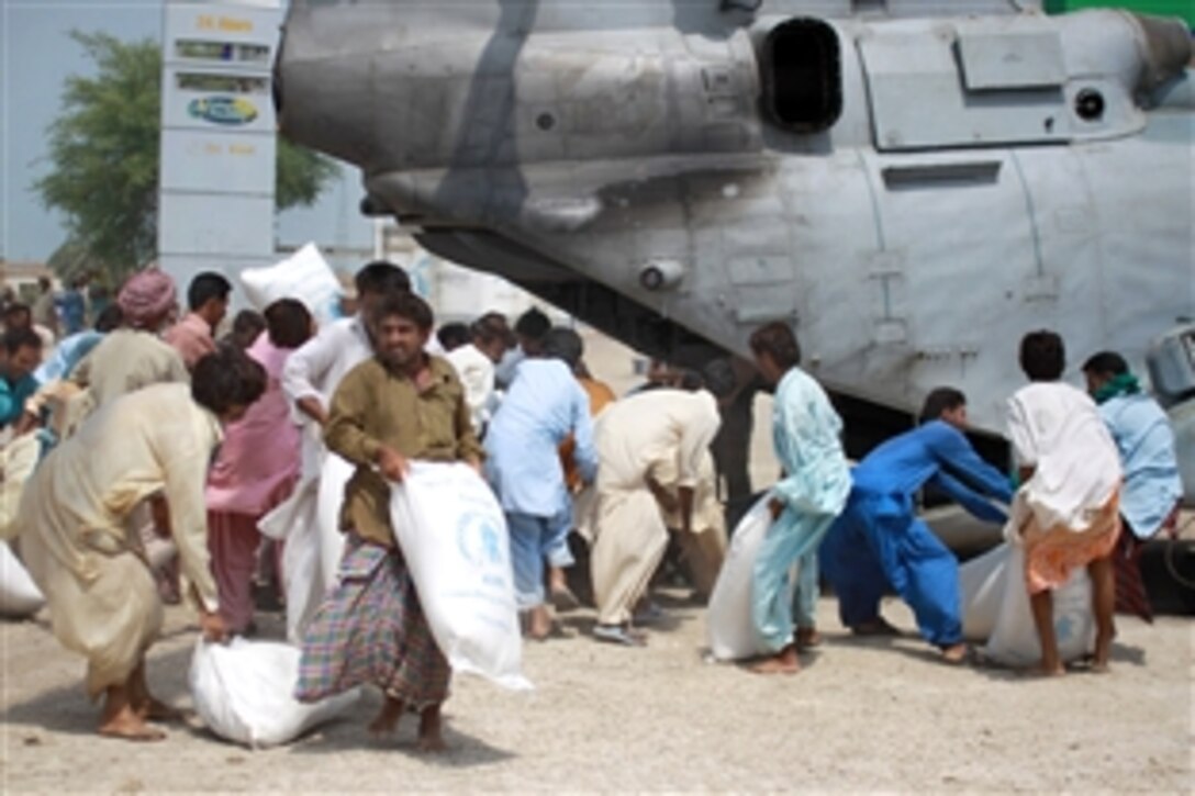 Pakistani flood victims rush to pick up relief supplies delivered by U.S. Marines during humanitarian assistance efforts in the southern region of Pakistan, Sept. 4, 2010. The Marines are assigned to Marine Medium Helicopter Squadron 165, 15th Marine Expeditionary Unit.