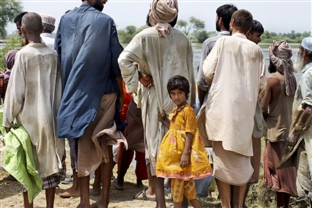 Pakistani flood victims wait to pick up relief supplies delivered by U.S. Marines during humanitarian relief efforts in the southern region of Pakistan, Sept. 4, 2010. The Marines are assigned to Marine Medium Helicopter Squadron 165, 15th Marine Expeditionary Unit.