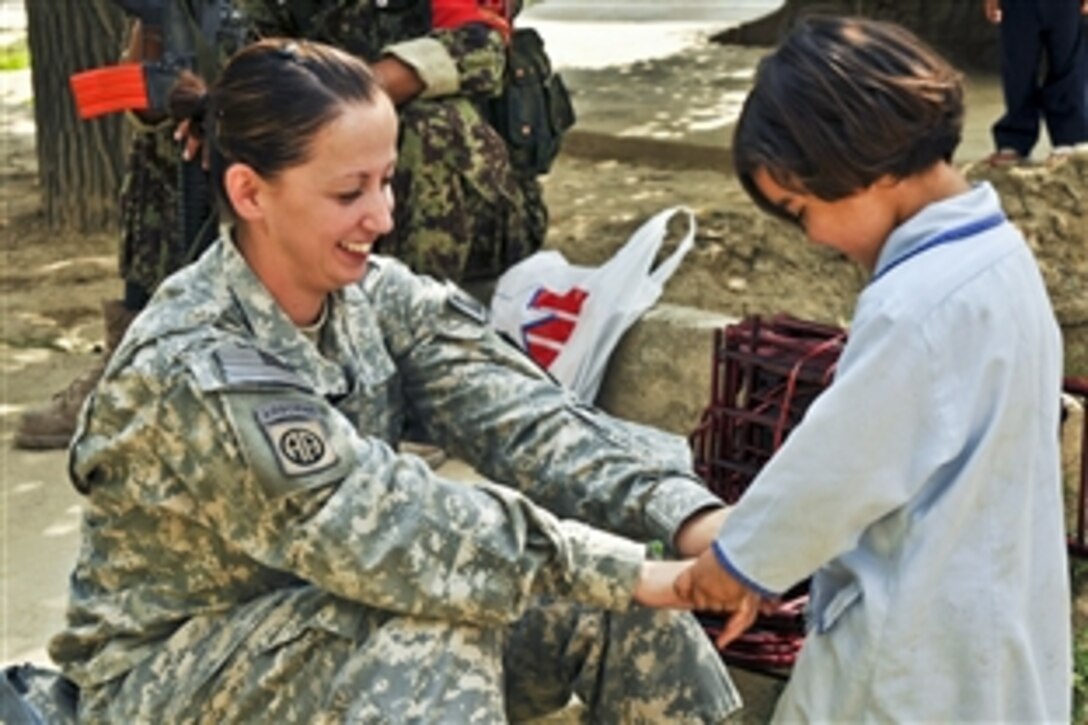 U.S. Army 1st Lt. Lisa Sanchez plays with a girl from an Afghan day care she visited in Kabul, Afghanistan, Sept. 5, 2010. Sanchez is a U.S. Forces Afghanistan procurement officer. A volunteer team from the U.S. force worked with Afghan soldiers to donate more than 100 items, including fans, blankets, TVs, wall lockers, shoe shelves and a couch to the day care.