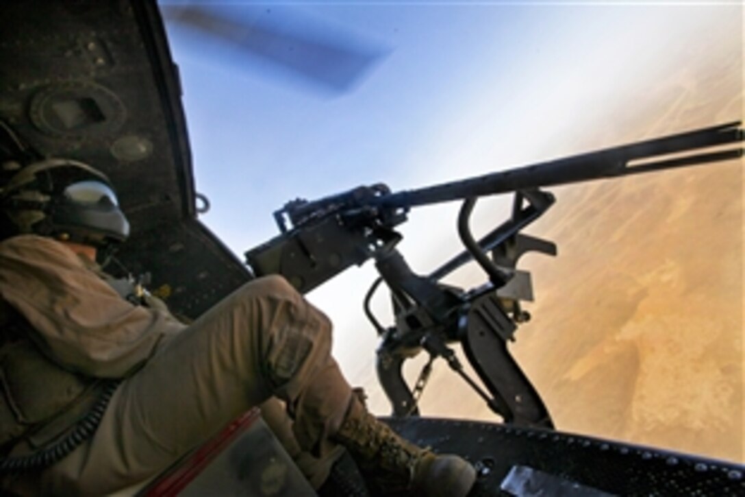 U.S. Marine Corps Cpl. Carson Ferraro mans a .50-caliber door gun while flying an aerial reconnaissance mission over Camp Baston, Afghanistan, Sept. 3, 2010. Ferraro, a UH-1Y Huey crew chief, is assigned to Marine Light Attack Helicopter Squadron 369, 3rd Marine Aircraft Wing.