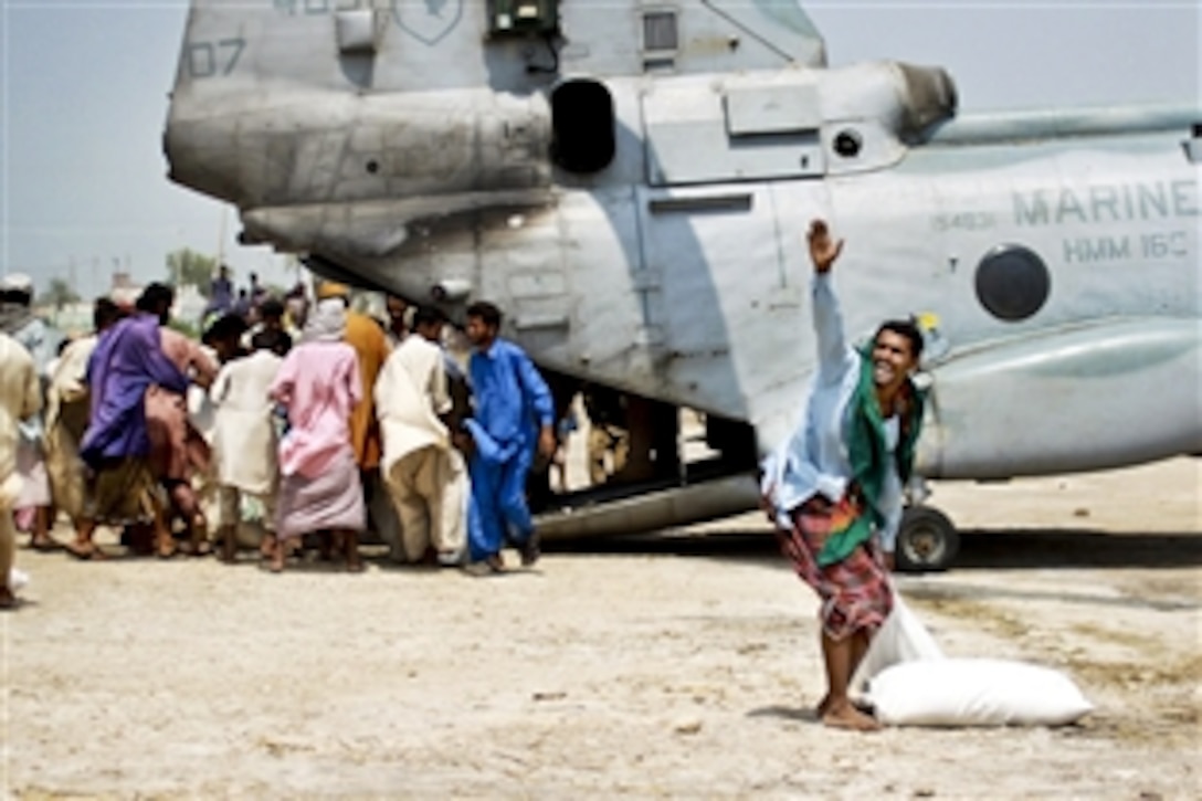 Pakistani flood victims rush to pick up relief supplies delivered by U.S. Marines during humanitarian assistance efforts in southern Pakistan, Sept. 4, 2010. The Marines are assigned to Marine Medium Helicopter Squadron 165, 15th Marine Expeditionary Unit.