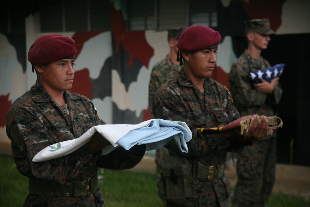 Guatemalan Army Special Forces soldiers or "Kaibiles" hold their national colors along with U.S. Marines at Poptun Training Camp in Poptun, Guatemala, Sept. 6.  From Sept. 5-12, Marines of Special-Purpose Marine Air-Ground Task Force Continuing Promise 2010 conducted a subject-matter expert exchange with Kaibil soldiers to give the Marines a sense of how the elite Guatemalan Special Forces soldiers train on a daily basis.