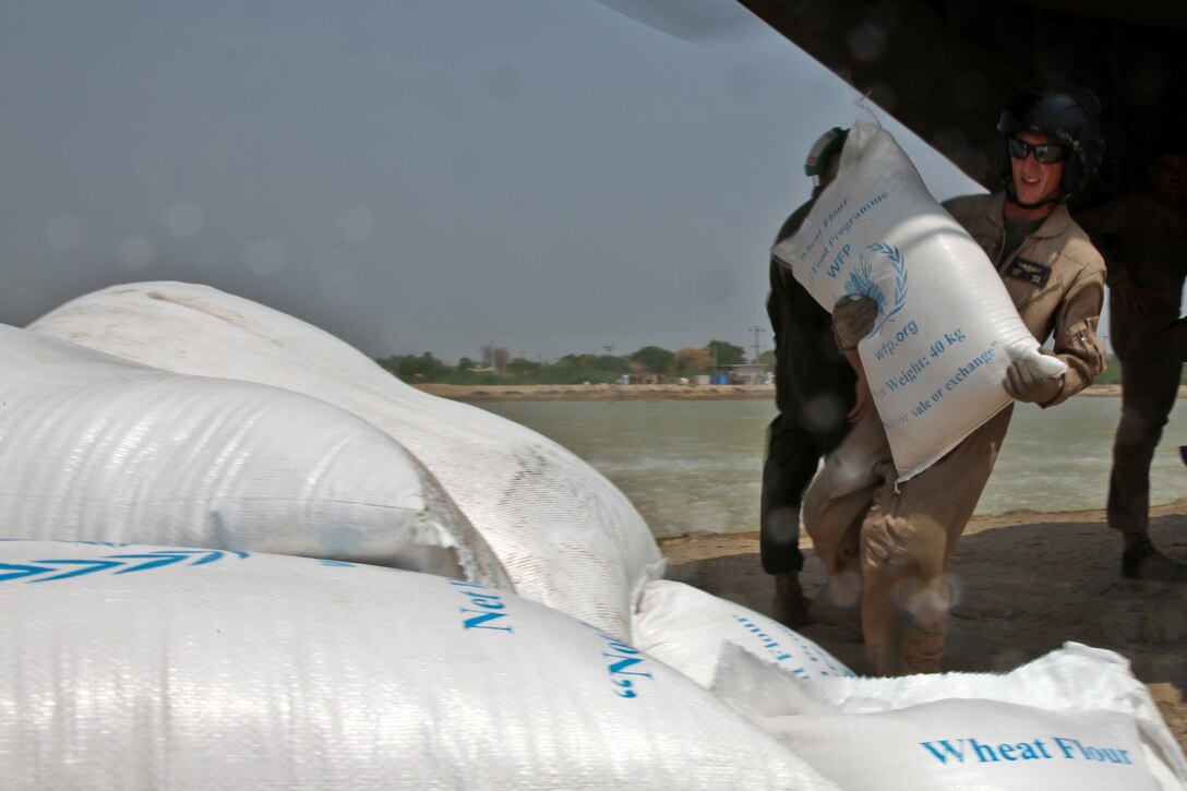 A U.S. Marine with the 26th Marine Expeditionary Unit unloads food and supplies for residents of Pano Aqil, Pakistan, Sept. 9, 2010, during flood relief efforts in that nation. (U.S. Army photo by Staff Sgt. Wayne Gray/Released)