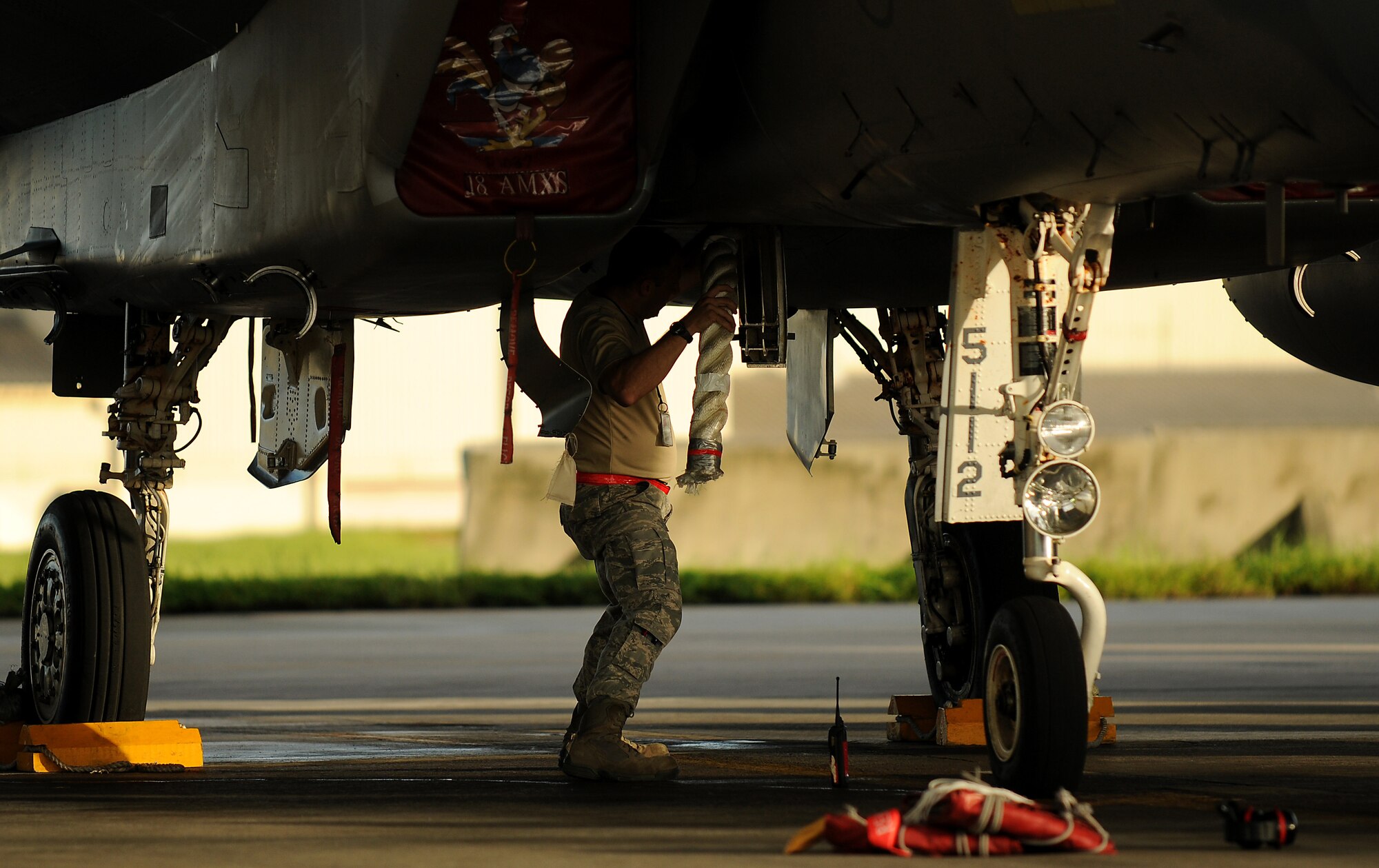 Senior Master Sgt. Eric Waaler, the lead production superintendent for the 67th Aircraft Maintenance Unit tucks a rope chock into an F-15, Sept. 8, before the aircraft departs for Valiant Shield, a joint training exercise held in Guam. More than 18 aircraft and 600 Kadena members deployed in support of the bi-annual operation. (US Air Force photo/Staff Sgt. Christopher Hummel)
