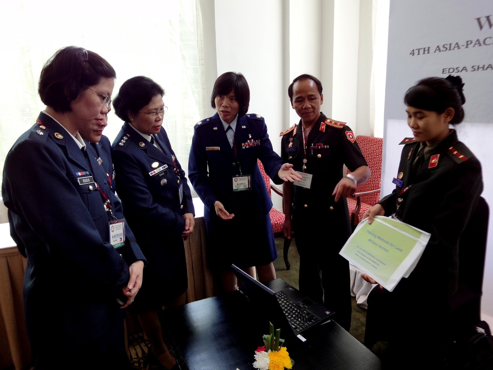 Maj. Chung Lee (center), the 13th Air Force international health specialist from Joint Base Pearl Harbor-Hickam, Hawaii, assisting the Laos delegations during a group discussion on Laos military nursing history as part of the 4th annual Asia-Pacific Nursing Conference Symposium where more than 200 nurses from 13 countries were in attendance.  The seven-day conference, hosted by the Armed Forces of the Philippines Office of the Chief Nurse, in collaboration with U.S. Pacific Command and 13th Air Force, focused on nursing education, career development, global pandemic preparedness and disaster management. The symposium was designed to help nurses in senior leadership positions share ideas and practices in order to build relations between Asia-Pacific countries. The symposium concluded Sep. 4, 2010.  (U.S. Air Force photo/ Tech. Sgt. Carlos Limo) 