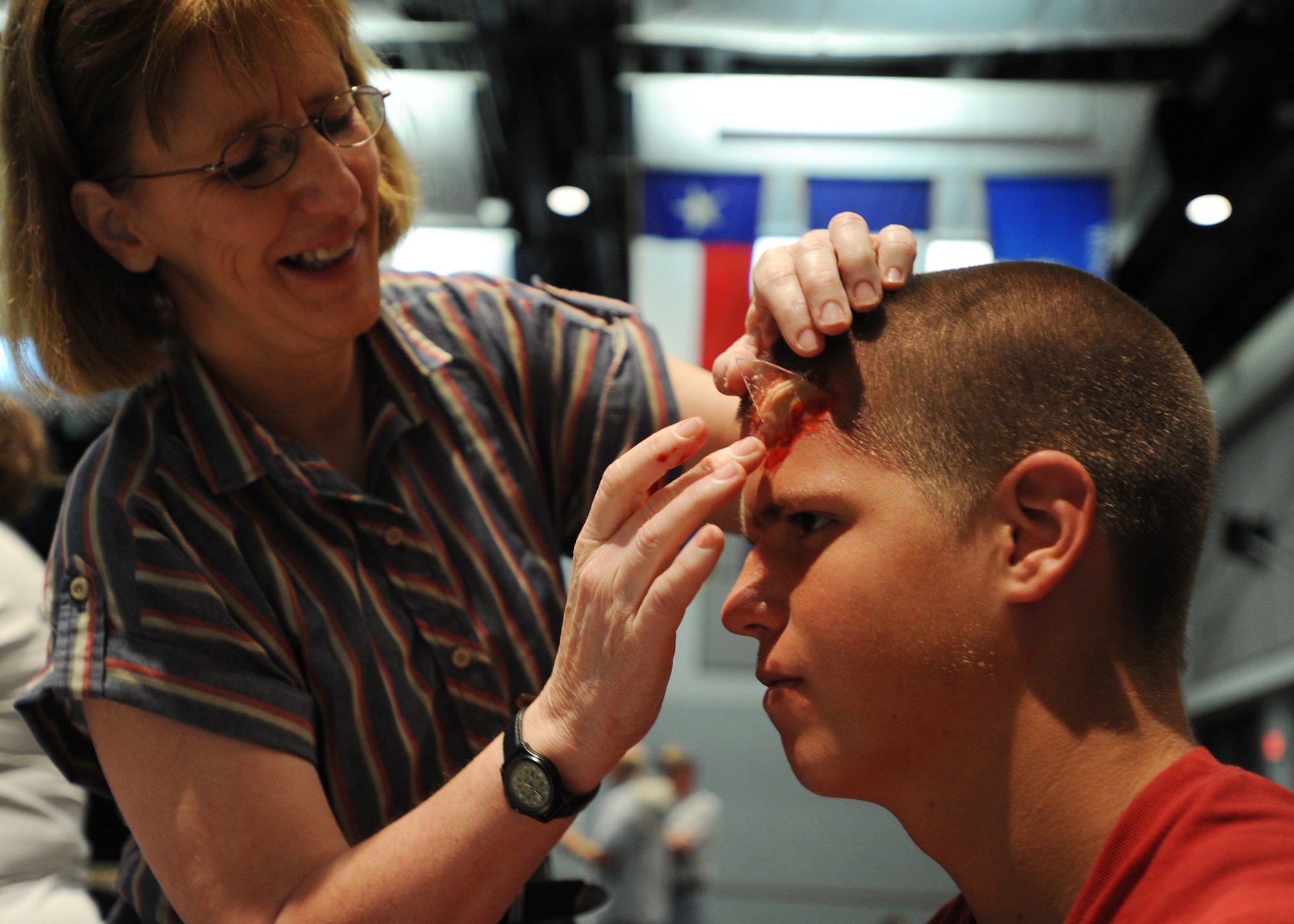 Leann Smith, a member from the Kansas Community Emergency Response Team, applies moulage makeup on Kyle Leey, a Derby High School Junior Reserve Officers’ Training Corps cadet, Sept. 1, 2010, McConnell Air Force Base, Kan.  Moulage requires the use of artificial blood, makeup and other materials to create patient scenarios.  (U.S. Air Force photo/Airman 1st Class Andrea Salazar)