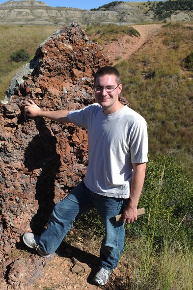 BADLANDS, N.D. -- Senior Airman Nathaniel Dykstra, 5th Communication Squadron land mobile radio technician, poses in front of a brick formation formed naturally from years of baking in the sun at the Theodore Roosevelt National Park here Sept. 3. Camping in the Theodore Roosevelt National Park allows one to explore the rugged badlands terrain and watch wildlife. (U.S. Air Force photo by Airman 1st Class Aaron-Forrest Wainwright)