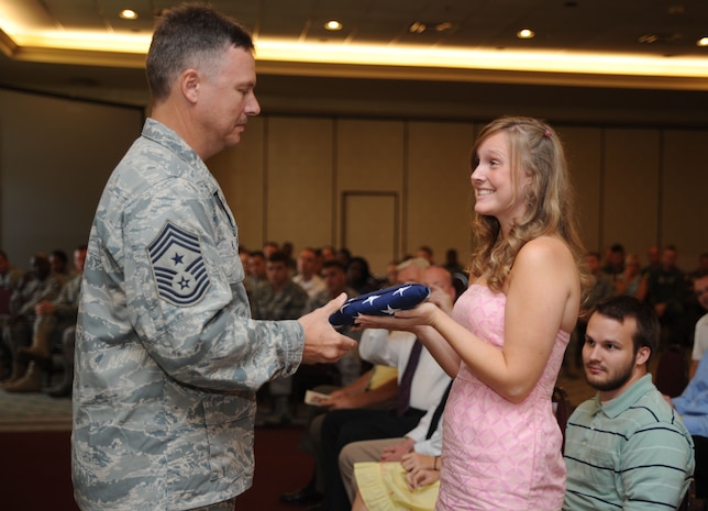 Chief Master Sgt.Mike Ivey presents the American flag to his daughter Amanda Bowling during his retirement ceremony at the Charleston Club on Joint Base Charleston, S.C., Aug. 20, 2010.  Chief Ivey is the 628th Air Base Wing command chief. (U.S. Air Force Photo/Airman 1st Class Lauren Main)