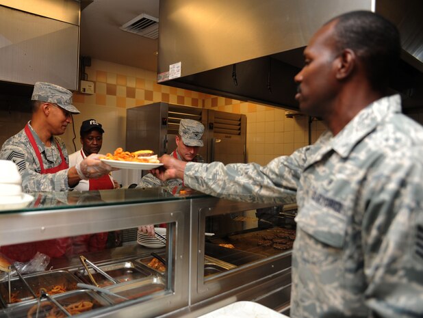 Chief Master Sgt. Terrence Greene and Col. John Wood serve lunch to Staff Sgt. Donald Robinson at the Gaylor Dining Facility on Joint Base Charleston, S.C., Sept. 1, 2010. The 437th command chief and commander sat down with 18 Airmen from various squadrons from the 437th Airlift Wing to discuss topics that concerned Airmen. The Airmen were also given a chance to ask their senior leadership questions during the quarterly luncheon. Chief Greene is the 437 AS command chief, Colonel Wood is the 437 AS commander and Sergeant Robinson is a medical administrator with the 315th Airlift Squadron. (U.S. Air Force Photo/Airman 1st Class Lauren Main)