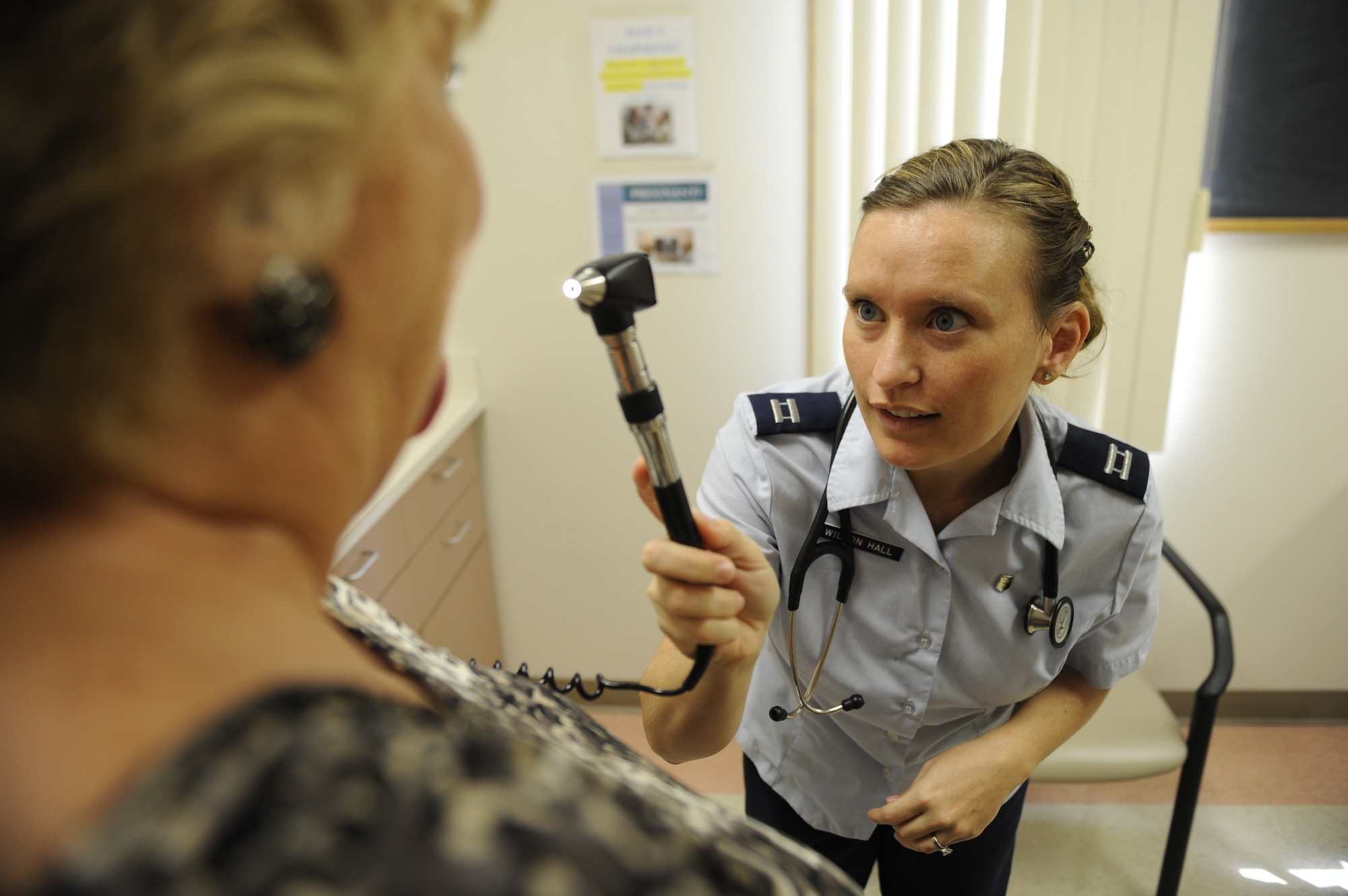 SCOTT AIR FORCE BASE, Ill. -- Dr. (Capt.) Nicole Wilson-Hall, a third year resident at the Belleville Family Medicine Clinic, checks a patient’s eyes Aug. 31. Doctor Wilson-Hall is one of 42 residents participating in the program. (U.S. Air Force photo/Staff Sgt. Ryan Crane) 