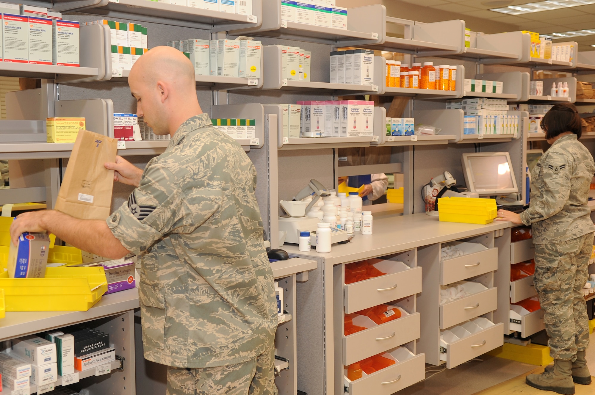 BUCKLEY AIR FORCE BASE, Colo. -- Staff Sgt Chris Plunkett and Airman 1st Class Christina Caputo, 460th Medical Group members, work to get prescriptions filled and ready for pick up at the new base pharmacy Sept. 7. (U.S. Air Force Photo by Airman Manisha Vasquez)