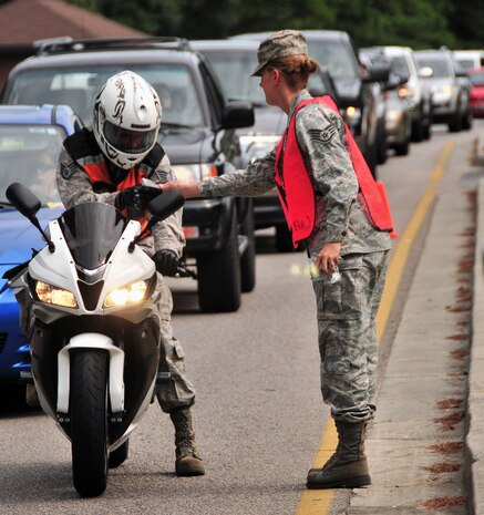 U.S. Air Force Staff Sgt. Amy Beamesderfer greets a motorcyclist exiting the Rivers Avenue Gate on Joint Base Charleston, S.C, Sept. 2, 2010. The sendoff was conducted to remind Team Charleston members embarking on the Labor Day holiday weekend to remain safety-minded. With the help of fellow volunteers, Sergeant Beamesderfer assisted in handing out approximately 3,000 safety whistles painted with the message "Safety ... Do it for the family." Sergeant Beamesderfer is a chaplain's assistant with the 628th Air Base Wing. (U.S. Air Force photo/Staff Sgt. Daniel Bowles)