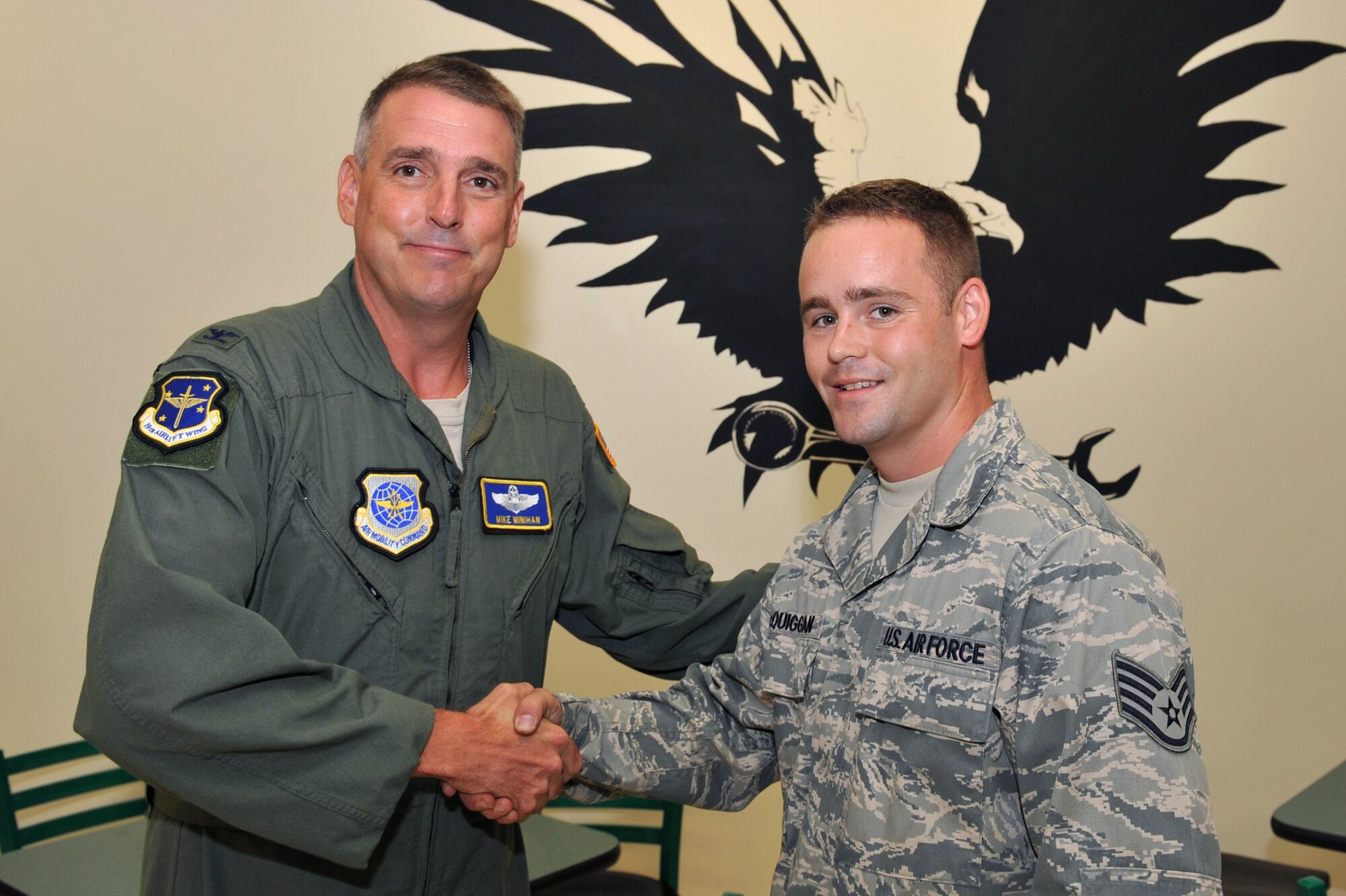 Col. Mike Minihan (left), 19th Airlift Wing commander, presents a coin here Sept. 8 to Staff Sgt. Ross McQuiggan, 19th Aircraft Maintenance Squadron aircraft maintenance journeyman, for his selection as the Combat Airlifter of the Week. Sergeant McQuiggan replaced a leaking propeller in under five hours, helping to generate six sorties during Operation Iraqi Freedom. (U.S. Air Force photo by Staff Sgt. Chris Willis)