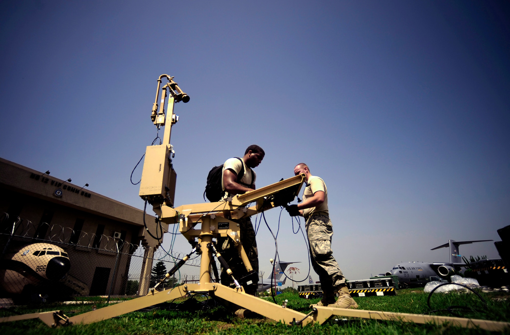 Airmen from the Contingency Response Element of the 818th Contingency Response Group, 621st Contingency Response Wing from Joint Base McGuire-Dix-Lakehurst, N.J., set up antennas for Internet and telephone capabilities during initial build-up Aug. 28, 2010, at Chaklala Air Force Base, Pakistan. The CRE arrived Aug. 28, 2010, to take over responsibilities for loading and off-loading U.S. aircraft with supplies for Pakistan flood relief efforts. (U.S. Air Force photo/Staff Sgt. Andy M. Kin) 