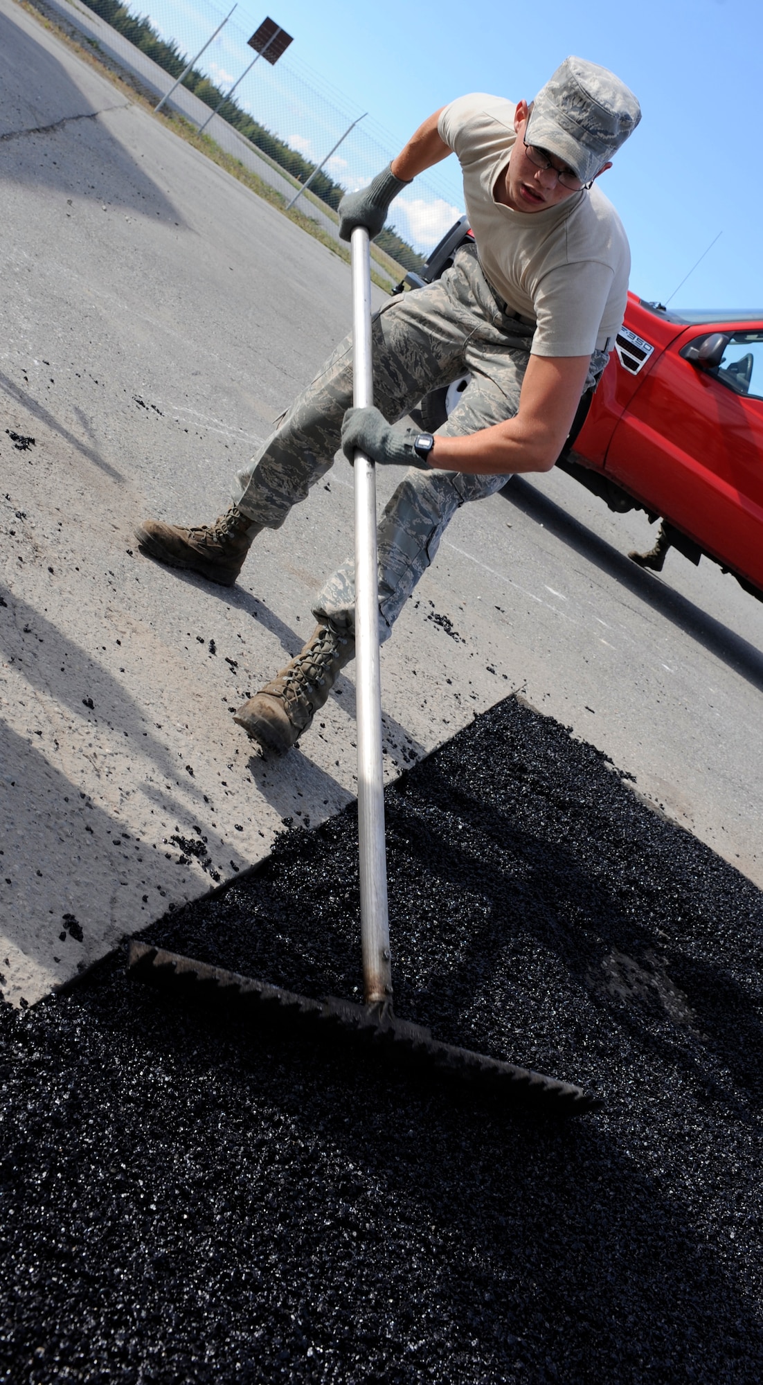 Airman 1st Class Derek Jorn spreads quick-set asphalt Sept. 1, 2010, Eielson Air Force Base, Alaska. The asphalt was being used to repair damaged roads around Eielson. Airman Jorn is a heavy equipment operator assigned to the 354th Civil Engineer Squadron. (U.S. Air Force photo/Senior Airman Willard E. Grande II)