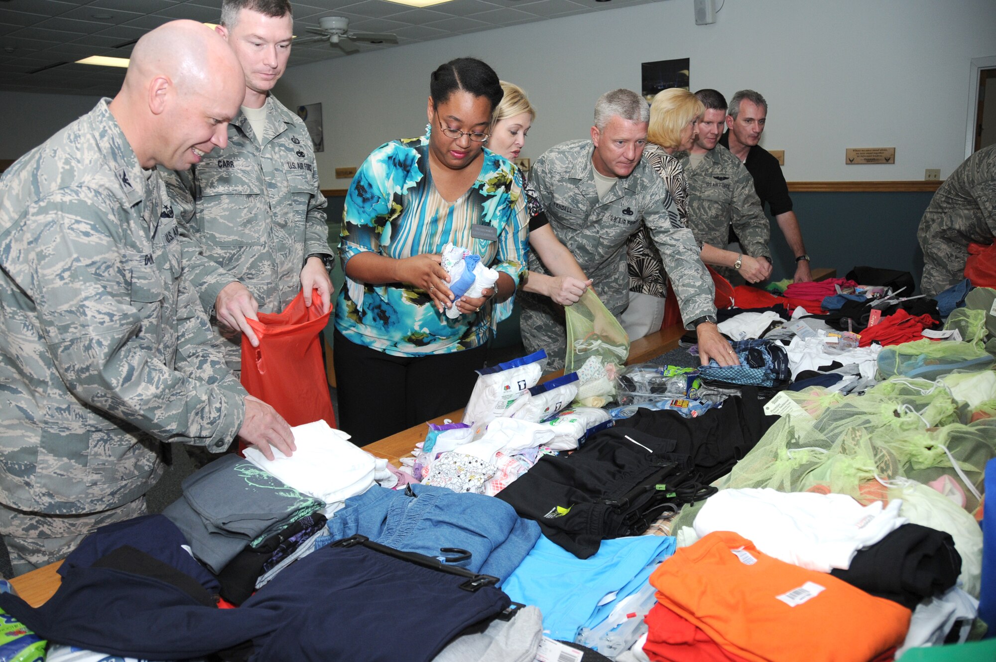 From left, Col. Glen Downing, 81st Training Wing vice commander; Tech Sgt. Dennis Carr, Little Rock Air Force Base, Ark.; Stephanie Piper and Rene Davis, Gulf Coast Women’s Center for Nonviolence; Chief Master Sgt. David Kendall, Mathies NCO Academy commandant; Tammy Jegel, victim advocate from the 81st Medical Support Squadron; Tech. Sgt. Jeremy Lynn, Little Rock AFB, and Barry Newman, Keesler sexual assault prevention and response program specialist, look at the items collected by the students of NCO Academy Class 10-6 for the women’s center.  (U.S. Air Force photo by Kemberly Groue)