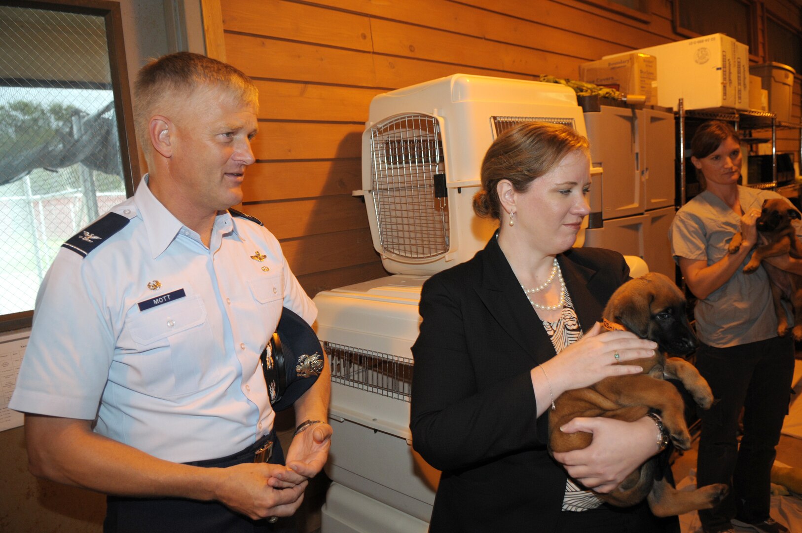 Erin Conaton, Under Secretary of the Air Force, and Col. William Mott, 37th Training Wing commander, visit the Military Working Dog Squadron. Secretary Conaton holds a puppy, which will be raised and trained for Security Forces Personnel in all branches in the Department of Defense. (U.S. Air Force photo by Joel Martinez)