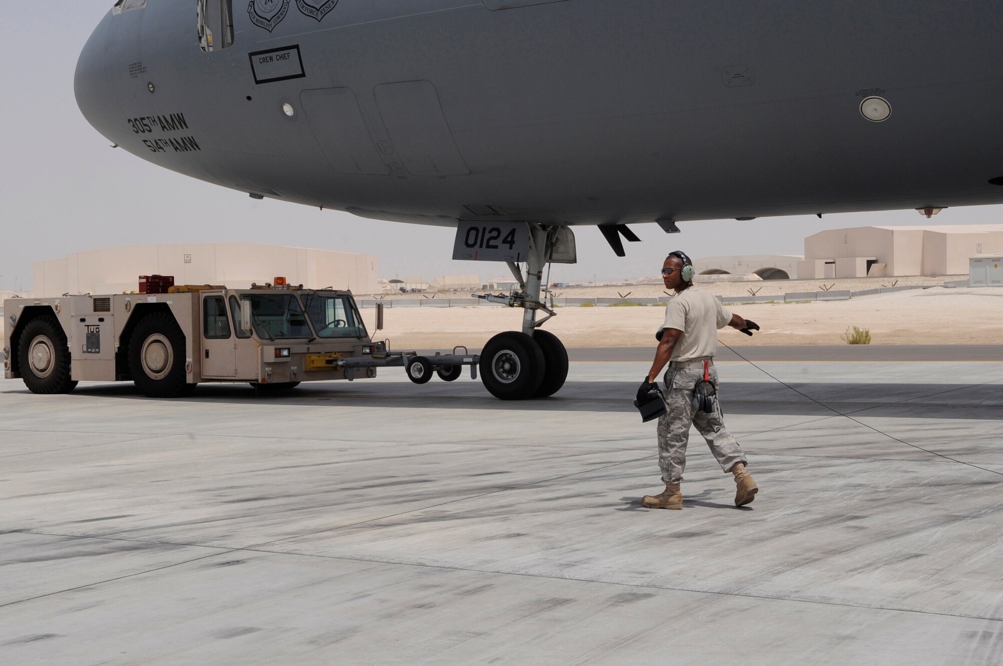 Staff Sgt. Ian Brown, 380th Expeditionary Aircraft Maintenance Squadron, directs a tow operation of a KC-10 Extendernon-disclosed base in Southwest Asia, Aug. 12, 2010. 