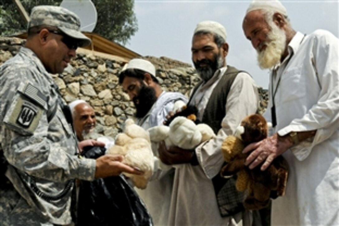 U.S. Army Sgt. Greg Locklear hands out toys donated by a child in the United States to local construction workers in eastern Kunar province, Afghanistan, Sept. 4, 2010. Locklear, a 
generator mechanic, is assigned to the 3rd Battalion, 321st Field Artillery.