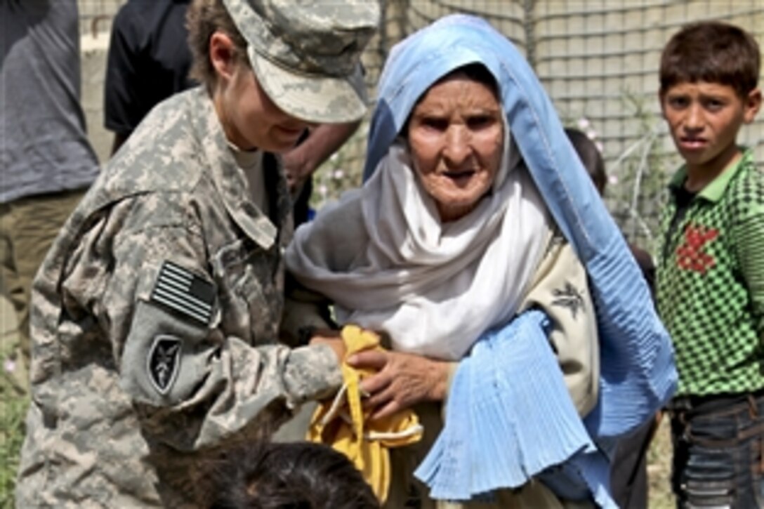 U.S. Army Sgt. Natanisha Hershberger helps an Afghan woman to her appointment at Egyptian Hospital in Afghanistan's Parwan province, Sept. 5, 2010. Hershberger and other Operation Care volunteers visited the hospital to distribute donated clothes, shoes and food to patients. Hershberger is a supply sergeant assigned to the 359th Theater Tactical Signal Brigade, Joint Net Operations Control.