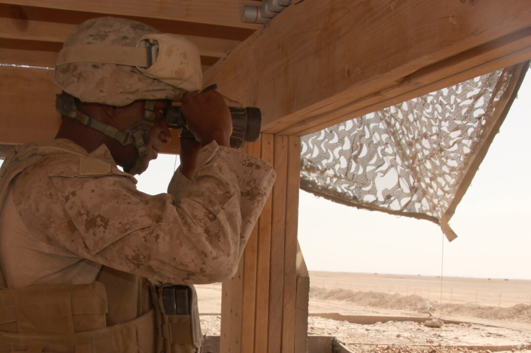 Lance Cpl. Timothy Daniels, a Base Defense Augmentation Force Marine with 3rd Low Altitude Air Defense Battalion, searches the horizon for movement at the base perimeter here.  Daniels and 32 other Marines volunteered for a three-month deployment to support 3rd Marine Aircraft Wing (Forward)’s requirement to augment the base defense force.  The Marines man guard towers, roam the base perimeter, and perform vehicle and personnel searches at the base's main entry points.