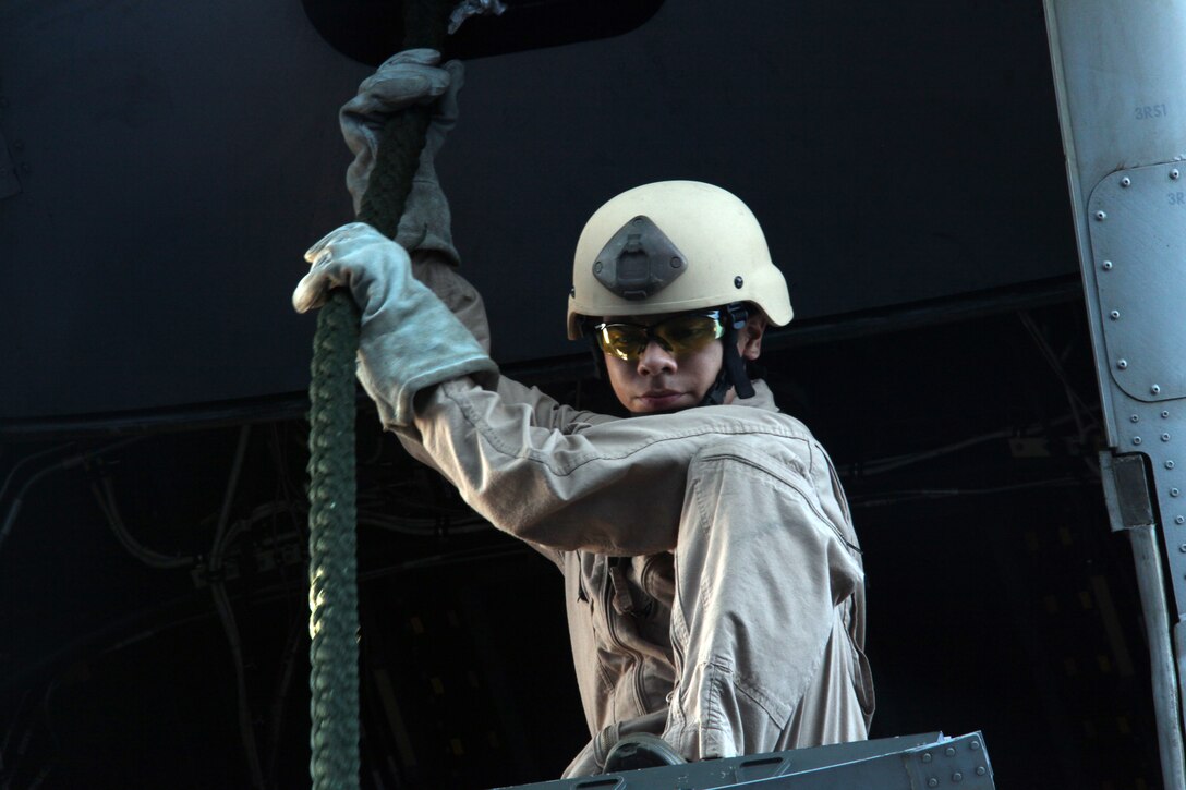 A reconnaissance Marine with Reconnaissance Platoon, Battalion Landing Team 3/8, 26th Marine Expeditionary Unit, looks down from the ramp of an MV-22 Osprey on the flight deck of USS Kearsarge waiting for clearance to allow Marines to fast-rope during a fast-rope qualification exercise, Sept. 9, 2010. 26th MEU deployed aboard the ships of Kearsarge Amphibious Ready Group in late August responding to an order by the Secretary of Defense to support Pakistan flood relief efforts.