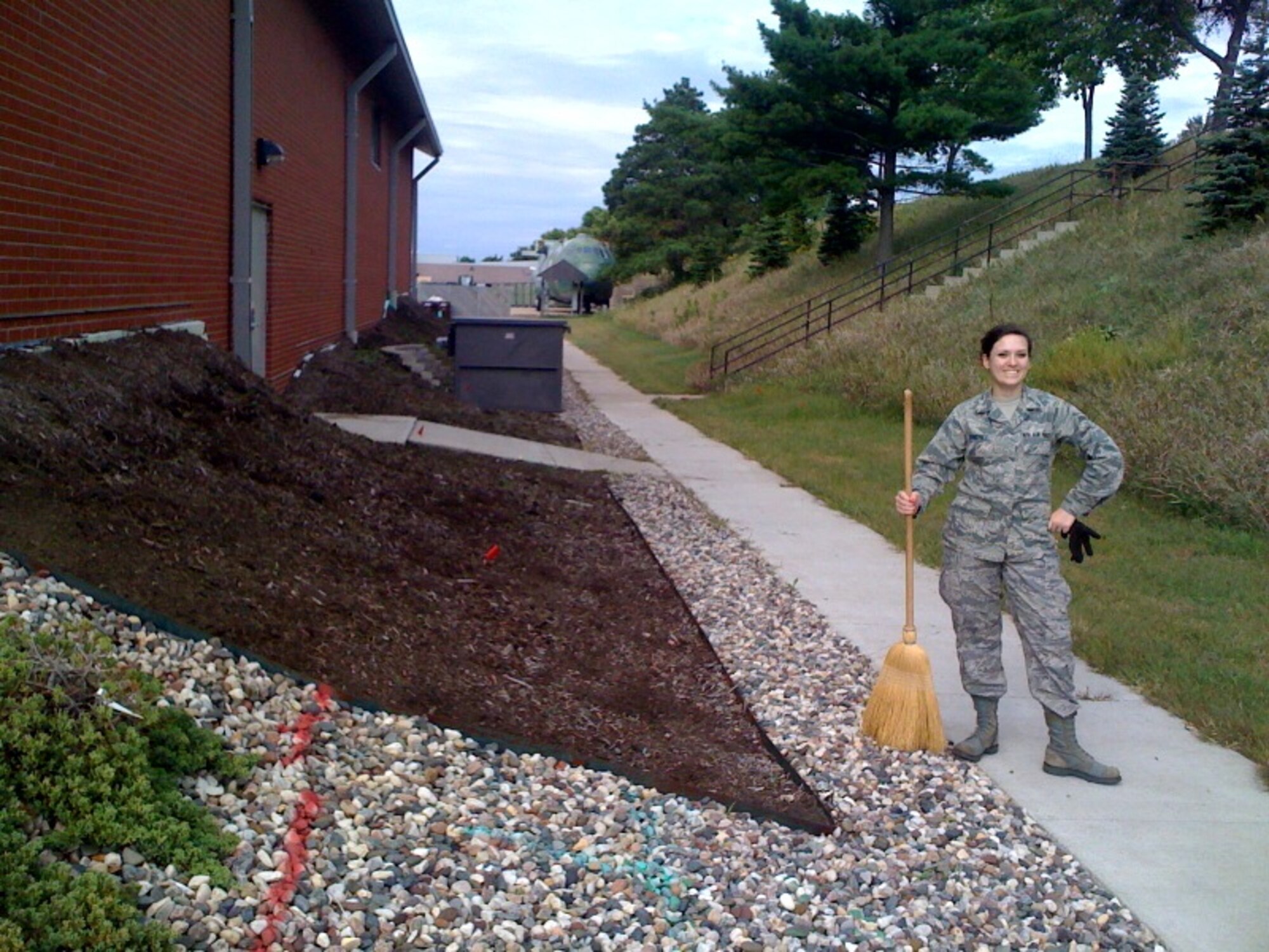 Airman First Class Reagann Sanchez, 934th Aeromedical Evacuation Sqadron, stands beside the AES building after the cleanup project Sept. 9. (Courtesy Photo)