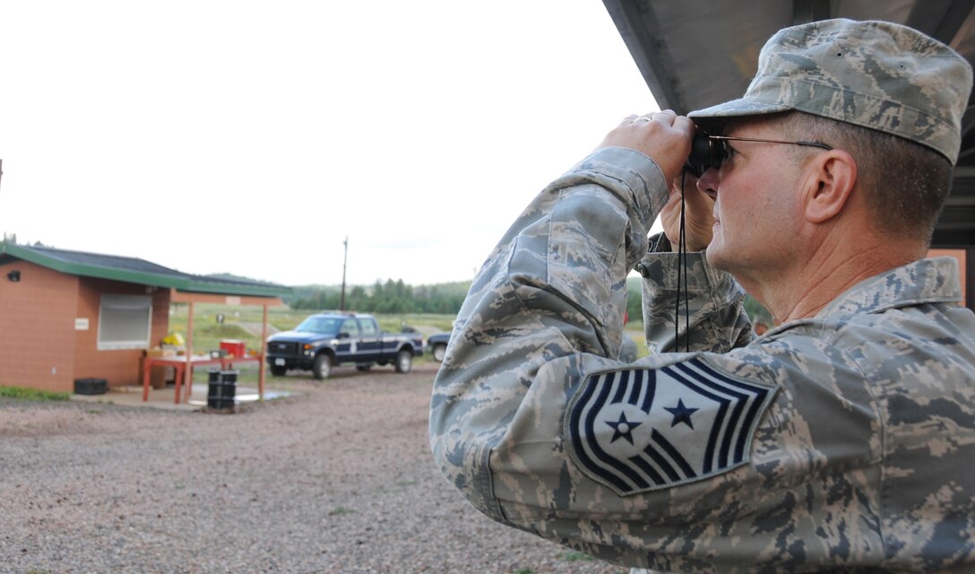 U.S. Air Force Chief Master Sgt. Dan Irving, Command Chief of the Arizona Air National Guard, scouts out the shooting range at Camp Navajo in Bellemont, Ariz., August 27, 2010. Chief Irving was one of 34 Air National Guard members who qualified on the M-9 and M-16 for expeditionary deployments. (U.S. Air Force Photo by Senior Airman Nicole Enos) 