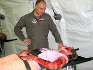Lt. Col. John Hall, a flight surgeon with the 162nd Medical Group, visits a mock patient with simulated burn injuries at an expeditionary medical support facility, or EMEDS, in Guam. Vigilant Guard 2010, held Aug. 23-26 on the pacific island, exercised the disaster response capabilities of several Guard units from around the country as well as those of local emergency responders. (Air Force photo)