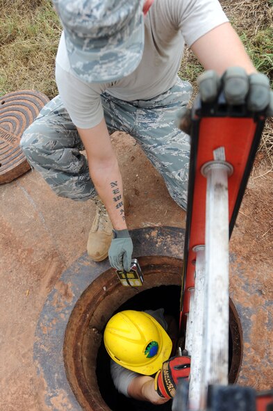 BARKSDALE AIR FORCE BASE, La. -- Senior Airman Ezekiel Newman, 2nd Communications Squadron antenna systems journeyman, watches as Airman 1st Class David Montroy, 2nd CS cable and antenna systems apprentice, enters the manhole Sept. 9. The 2nd CS manages communications
service contracts, payment of base bills and provides deployable communications equipment and trained personnel to support initial bare base or augmentation communications for expeditionary forces. (U.S. Air Force photo by Senior Airman Brittany Y. Bateman)(RELEASED)
