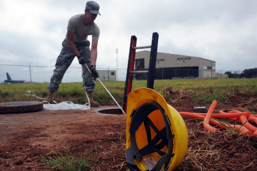 BARKSDALE AIR FORCE BASE, La. -- Senior Airman Ezekiel Newman, 2d Communications Squadron Antenna Systems Journeyman pulls the pull rope and the cable through the manhole Sept. 9. The 2nd CS manages communications service contracts, payment of base bills and provides deployable communications equipment and trained personnel to support initial bare base or augmentation communications for expeditionary forces. (U.S. Air Force photo by Senior Airman Brittany Y. Bateman)(RELEASED)