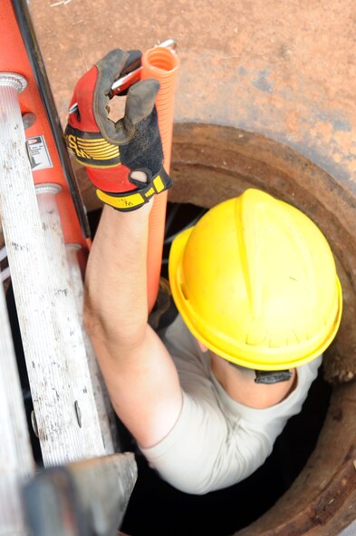 BARKSDALE AIR FORCE BASE, La. -- Airman 1st Class David Montroy, 2nd Communications Squadron antenna systems apprentice removes excess innerduct from a manhole Sept. 9. The 2nd CS manages communications service contracts, payment of base bills and provides deployable communications equipment and trained personnel to support initial bare base or augmentation communications for expeditionary forces. (U.S. Air Force photo by Senior Airman Brittany Y. Bateman)(RELEASED)
