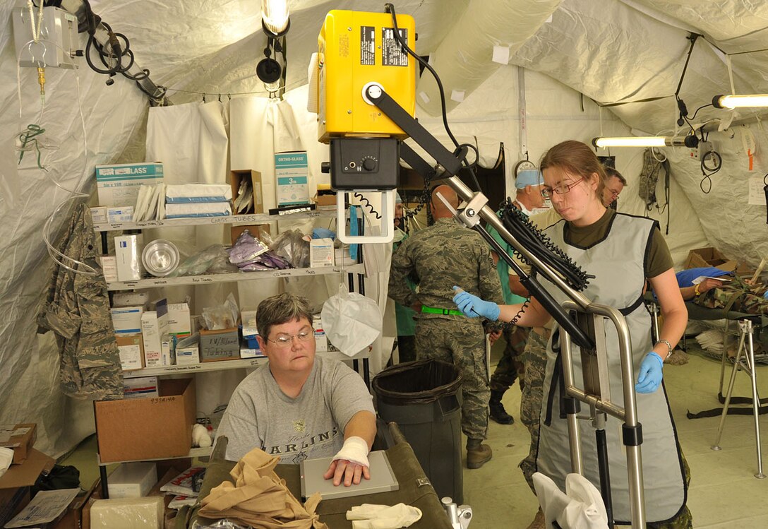 Canadian Land Forces Command Master Cpl. Caroline Turcotte, right, an x-ray technician assigned to Field Ambulance, prepares to x-ray the hand of a simulated victim during exercise Patriot 2009 at Volk Field Combat Readiness Training Center, Camp Douglas, Wis., July 20, 2009. (U.S. Air Force photo by Master Sgt. Kenneth Pagel/Released)