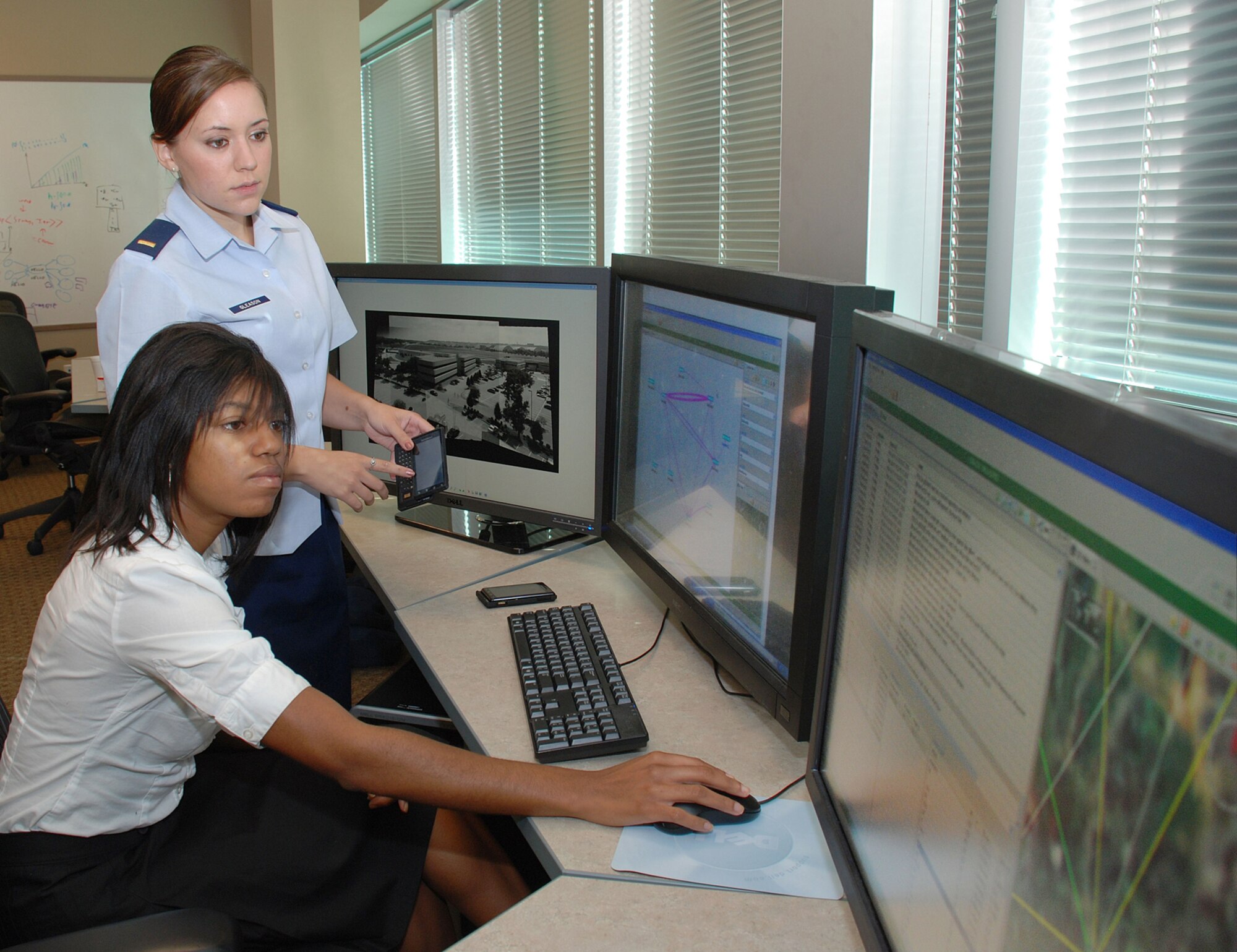 Second Lt. Katherine Gleason and Kelcey McKinney, a student from Ohio State University, study social networking patterns Aug. 6, 2010, in the 711th Human Performance Wing's Air Force Research Laboratory at Wright-Patterson Air Force Base, Ohio.  They are using the Behavior Modeling Branch's CityBeat Project's analysis tools to assist in behavior evaluation. (U.S. Air Force photo/Chris Gulliford)