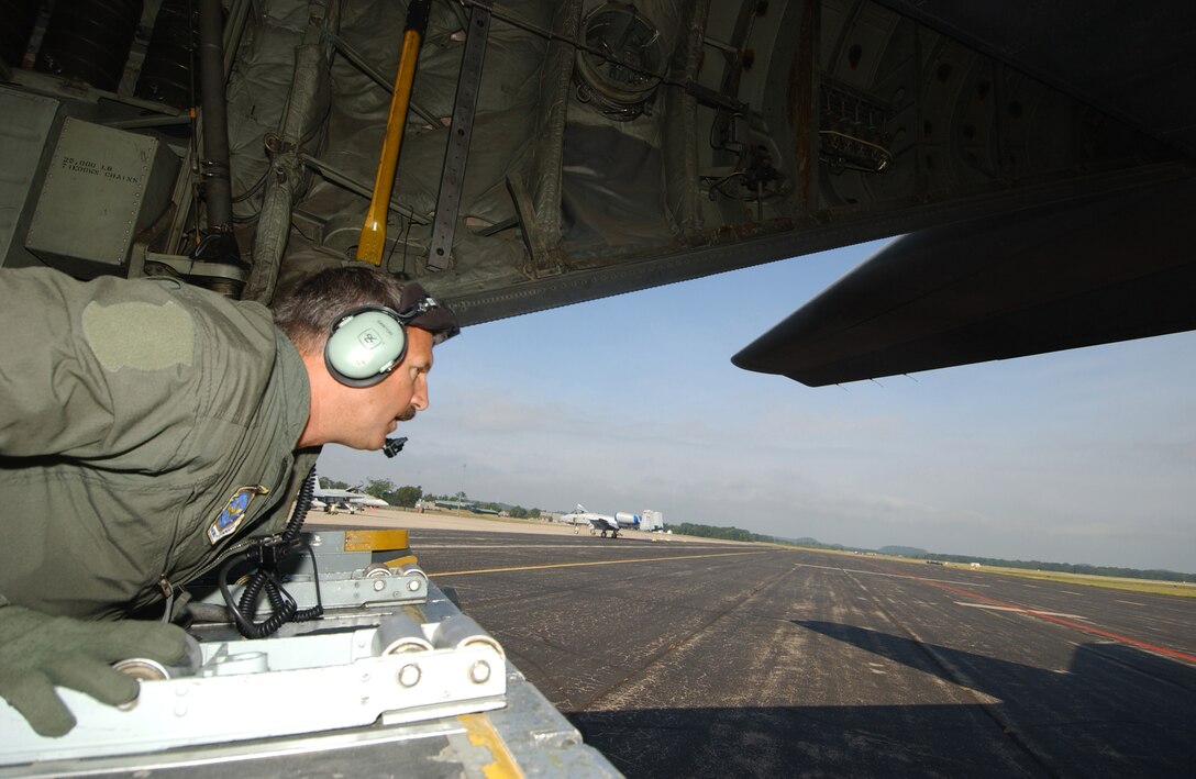 Chief Master Sergeant, Chris Santor, load master, 192nd Airlift Squadron, Reno Nevada, directs the C-130 Hercules while backing up at PATRIOT 2006, Volk Field, WI., July 19, 2006. PATRIOT is the premier National Guard Bureau sponsored joint exercise. This exercise increases the warfighting capabilities of the National Guard, reserve, and active components of the Air Force and Army. Additionally, Canadian, United Kingdom, and Dutch forces are participating, increasing combined effectiveness. (US Air Force photo by MSgt Robert A. Whitehead) (Released). 