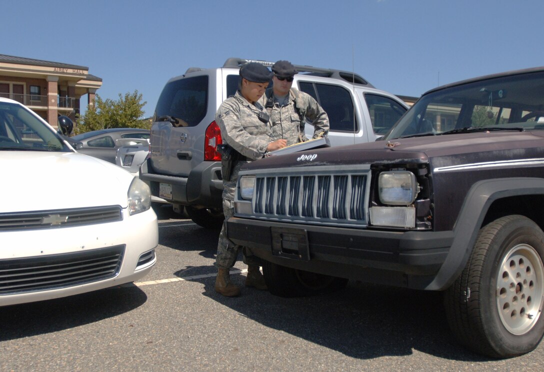 LANGLEY AIR FORCE BASE, Va. -- Airman 1st Class Kathy Shih (left) and Senior Airman Mathew Delmonico, 633d Security Forces Squadron patrol, prepare a citation for an abandoned vehicle at the Langley Airman dormitories Sept. 9. The 633 SFS will ticket illegally parked vehicles base-wide during Operation Clean Sweep Sept. 29-30. Owners of ticketed vehicles will have 72 hours following the citation to move the vehicle or face the expense and inconvenience of towing and impoundment. (U.S. Air Force photo/Airman 1st Class Jason J. Brown) (RELEASED)