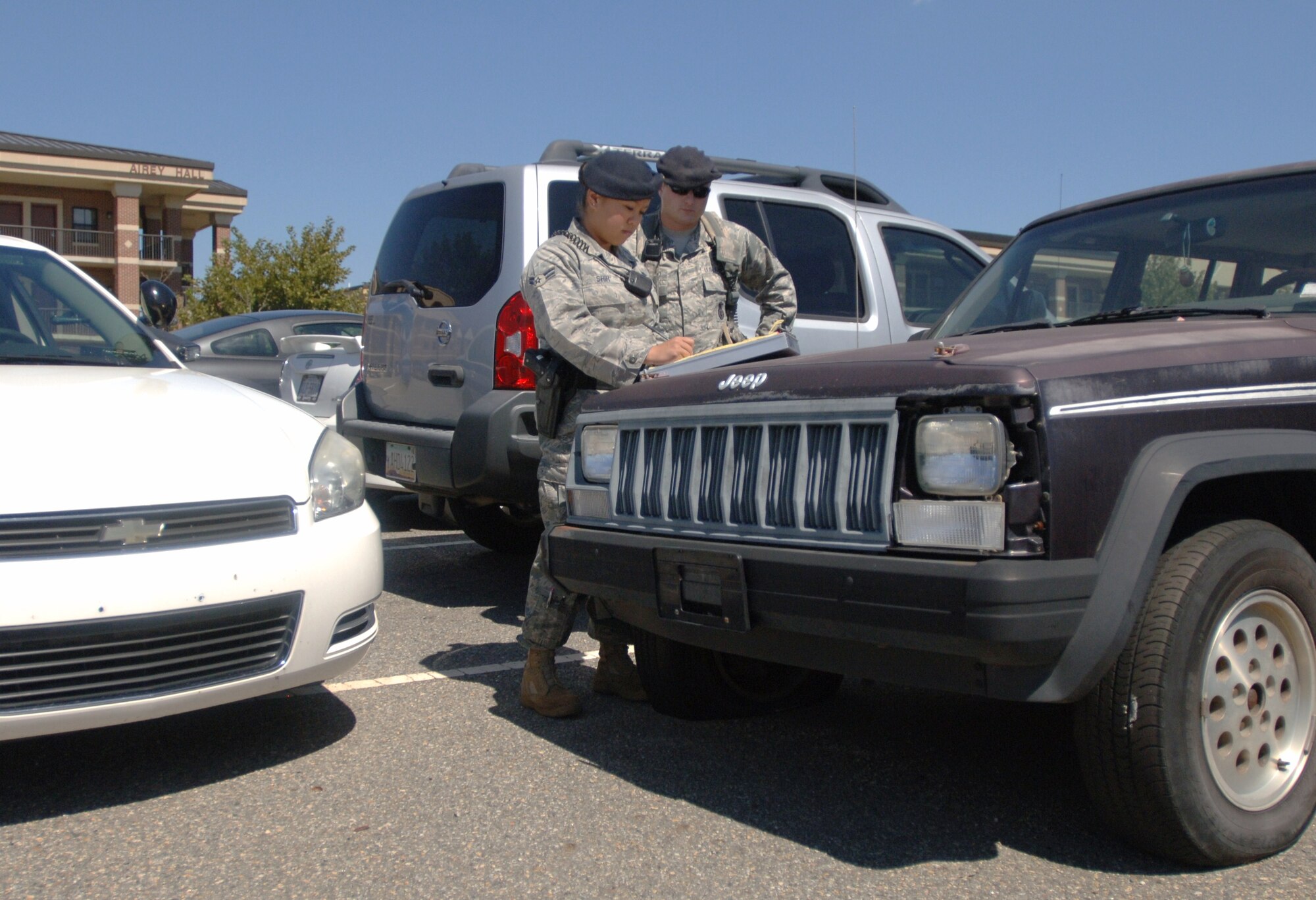 LANGLEY AIR FORCE BASE, Va. -- Airman 1st Class Kathy Shih (left) and Senior Airman Mathew Delmonico, 633d Security Forces Squadron patrol, prepare a citation for an abandoned vehicle at the Langley Airman dormitories Sept. 9. The 633 SFS will ticket illegally parked vehicles base-wide during Operation Clean Sweep Sept. 29-30. Owners of ticketed vehicles will have 72 hours following the citation to move the vehicle or face the expense and inconvenience of towing and impoundment. (U.S. Air Force photo/Airman 1st Class Jason J. Brown) (RELEASED)
