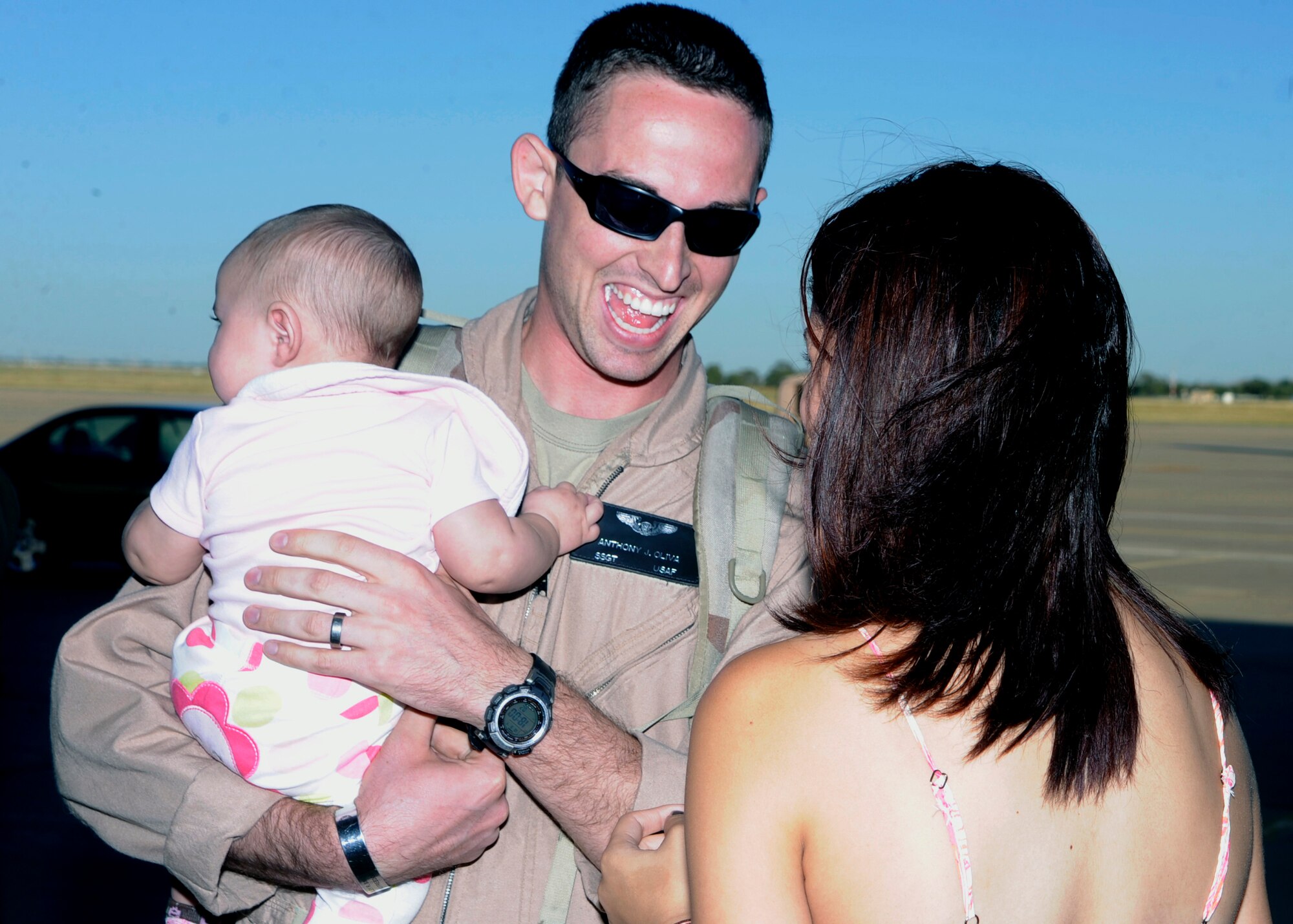 Staff Sergeant Anthony Oliva is all smiles as he holds his daughter Isabel and speaks with his wife Maria following his return to Cannon Air Force Base, N.M. Sept. 4. Thirty-three Airmen returned home following their deployments to Southwest Asia.  (U.S. Air Force photo by Greg Allen) (Released)