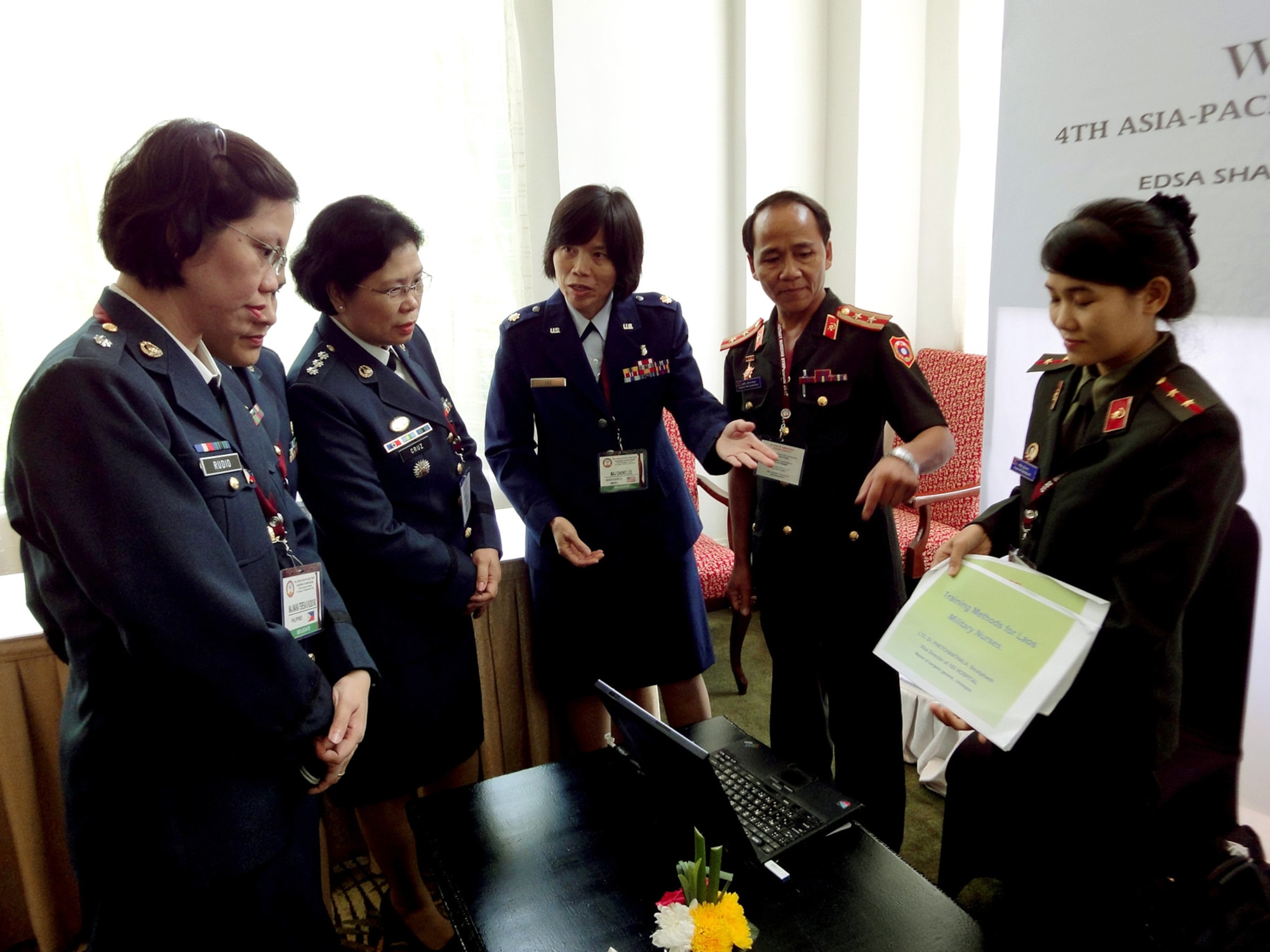 Maj. Chung Lee (center) assists the Laos delegations during a group discussion on Laos' military nursing history as part of the 4th annual Asia-Pacific Nursing Conference Symposium, where more than 200 nurses from 13 countries were in attendance. The symposium was designed to help nurses in senior leadership positions share ideas and practices in order to build relations between Asia-Pacific countries. Major Lee is the 13th Air Force international health specialist from Joint Base Pearl Harbor-Hickam, Hawaii. (U.S. Air Force photo/Tech. Sgt. Carlos Limo) 