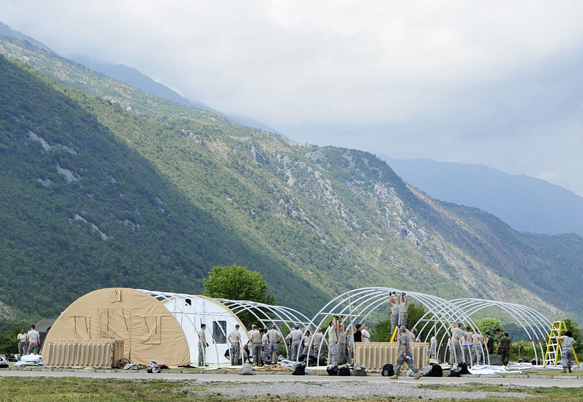 Armed forces members from different nations work together to set up medical tents in preparation for MEDCEUR 2010, a medical training exercise for central and eastern Europe, at Danilovgrad Army Base, Montenegro, Sept. 9. A total of ten nations are participating in the exercise. For more information visit www.usafe.af.mil/medceur.asp and www.odbrana.gov.me. (U.S Air Force photo/Airman 1st Class Tiffany Deuel)